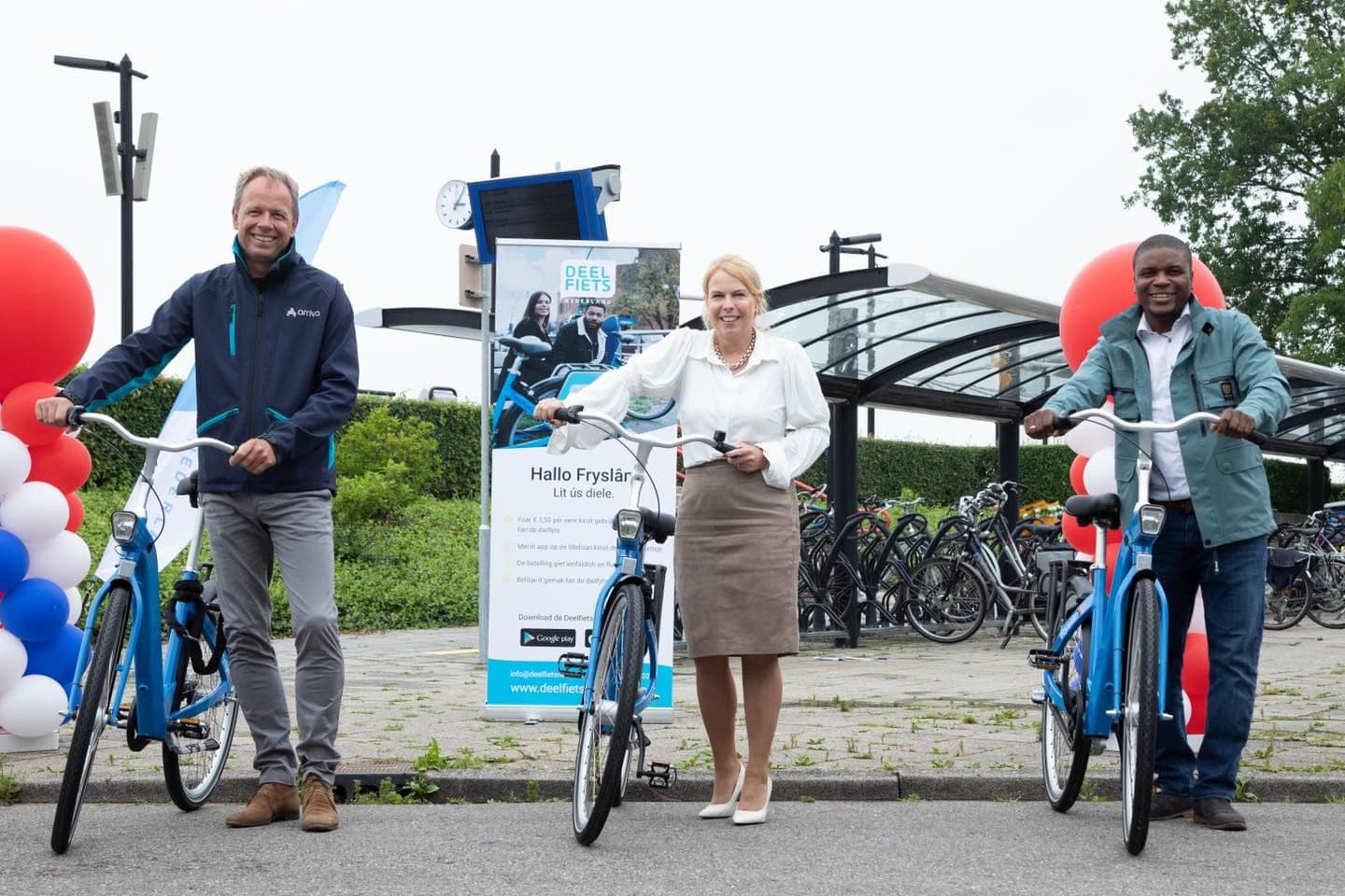 Oumar Sylla met gebruikers van de deelfiets bij de opening van de droppointlocaties van Deelfiets Nederland in Friesland