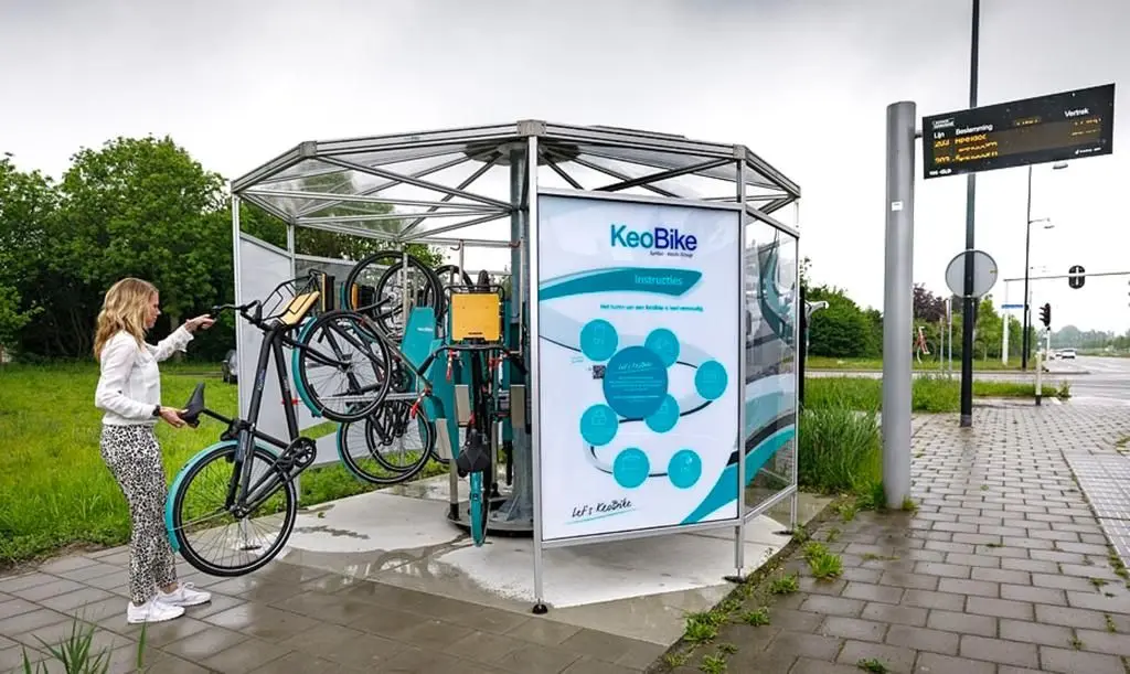 Een gebruiker die een deelfiets van Deelfiets Nederland in een KeoBike-rek plaatst