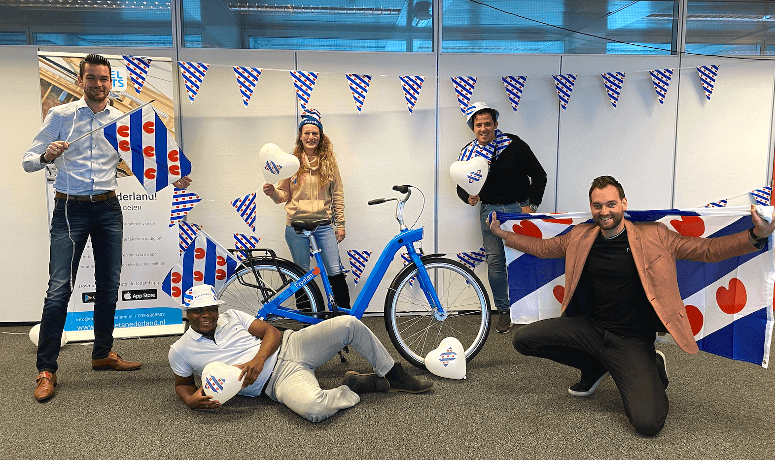 Het team van Deelfiets Nederland, met Friesse accessoires op het kantoor