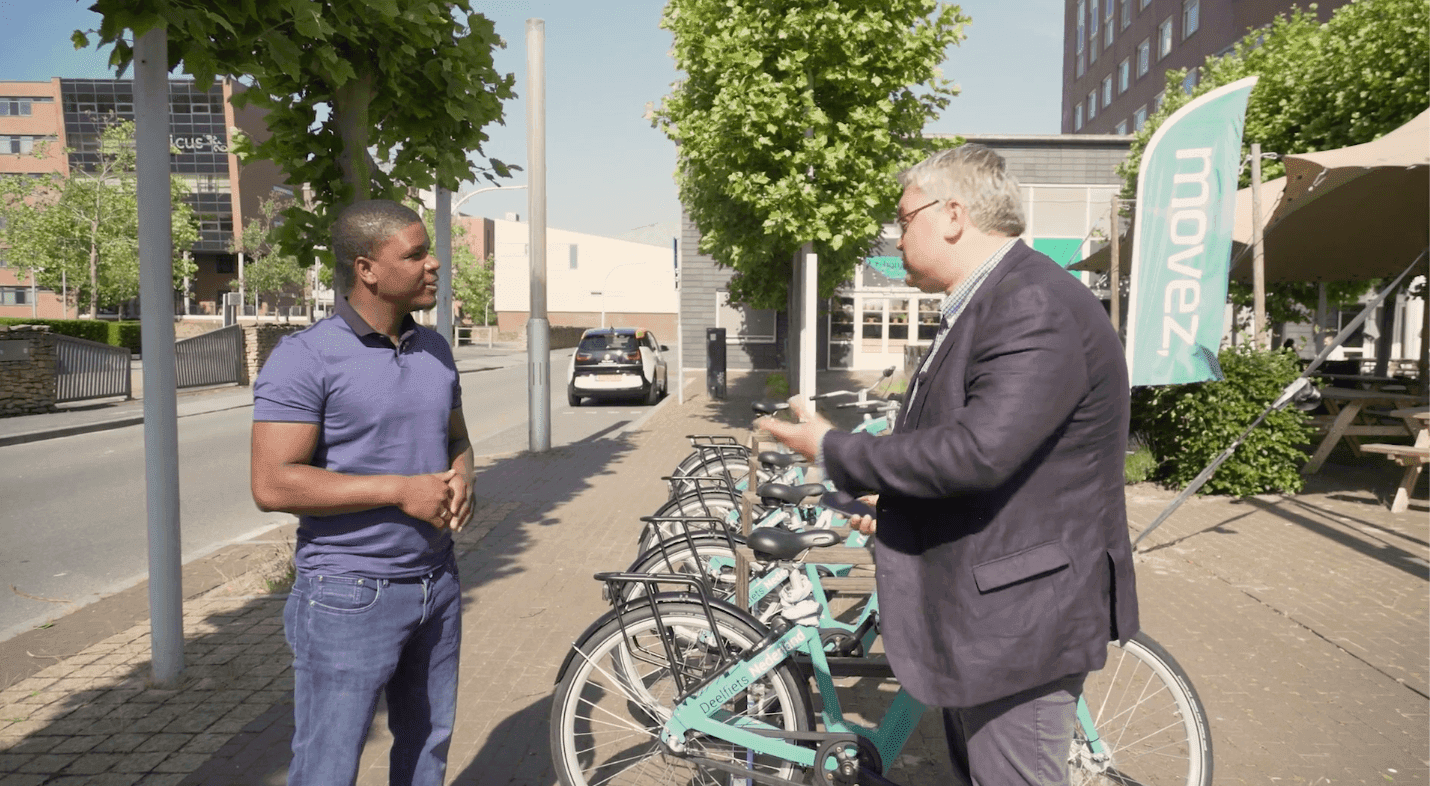 De eigenaar van Deelfiets Nederland in gesprek met een persoon bij de droppointlocatie van de deelfietsen van Movez